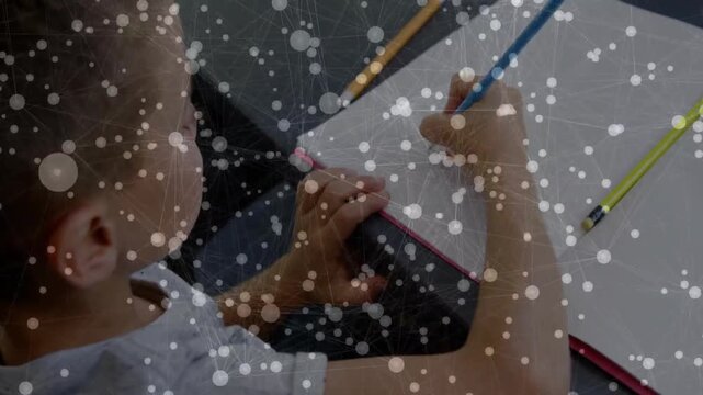 Boy placing blue pencil and writing on notebook left hand steadying overlay covering for education