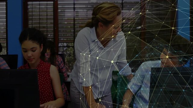 Teacher entering from right, leaning and pointing at student screen, assisting in classroom mesh