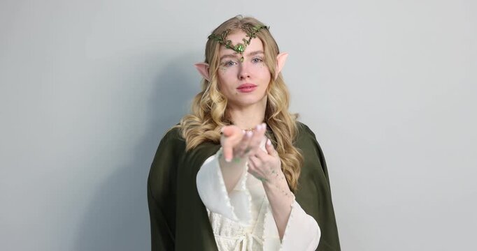 Beautiful elf girl posing on light grey background, camera moving in