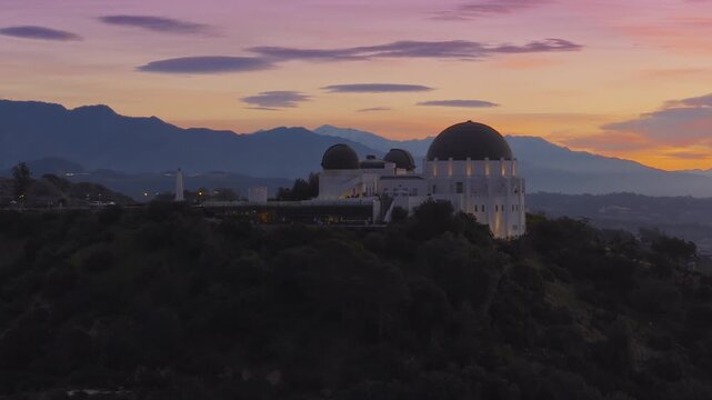 Los Angeles, California USA - FEBRUARY 27, 2026: Aerial view of Griffith Observatory in dawn light before sunrise with pastel sky mountain silhouettes and calm cinematic atmosphere above the hills.