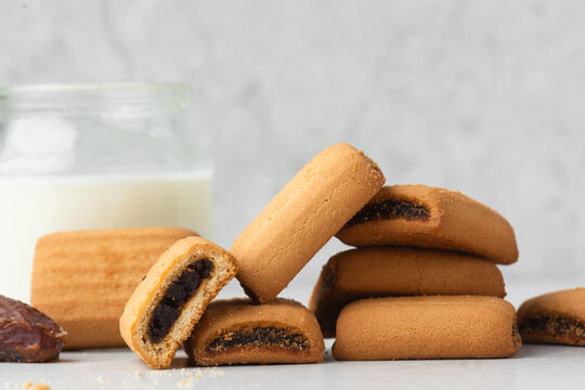 closeup view of date cookies on a white marble countertop, date filled sugar cookies on white textured background, homemade maamoul cookie bars on white tray