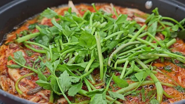A video of mushroom hot pot stew with water parsley in spring season boiling