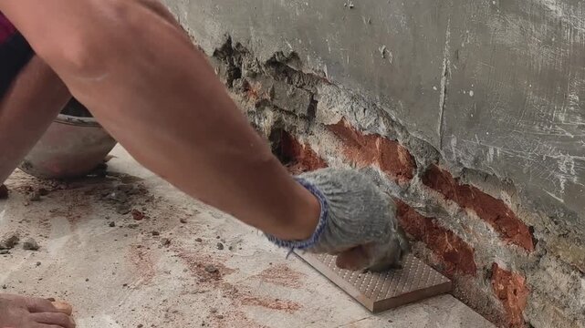 Close Up of Worker Hands Installing Wall Tiles with Cement