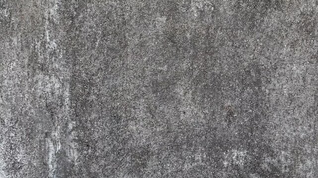 Weathered gray concrete wall texture with rough gritty surface and dark stains