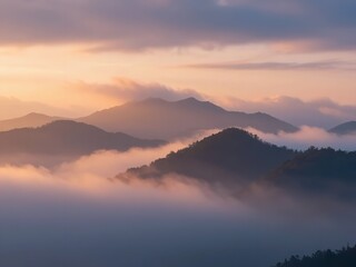 Fototapeta premium Tranquil sunrise over misty mountains with soft pastel sky and rolling fog