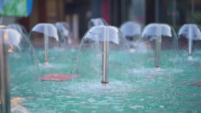 Water fountain jets close up view, Decorative fountain water flow in city, Modern fountain bubbles slow motion, Urban water feature with splashing jets stock video.