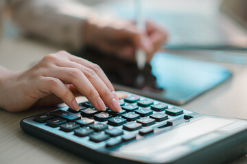 businesswoman using calculator on desk, representing digital finance, accounting, online banking, budgeting, tax management and modern fintech workflow in office