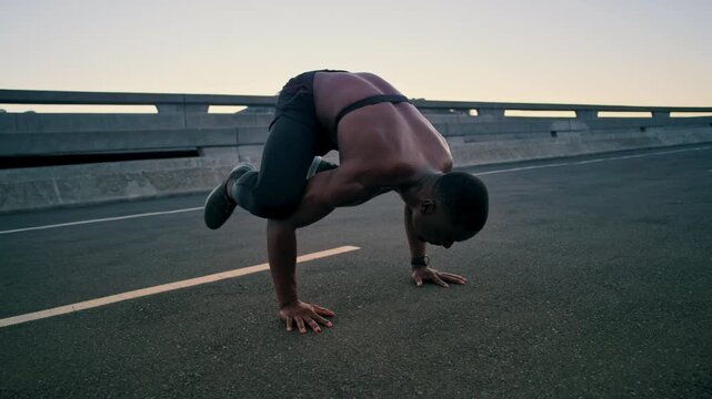 Man, handstand and push up in city for fitness with balance, strong muscle and outdoor on bridge. African person, calisthenics and heart rate monitor for wellness, exercise and flexible in urban town