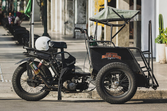 Yogyakarta - Indonesia, March 22, 2026 : A side view of a parked Bentor, a unique Indonesian motorized pedicab, on a city street.