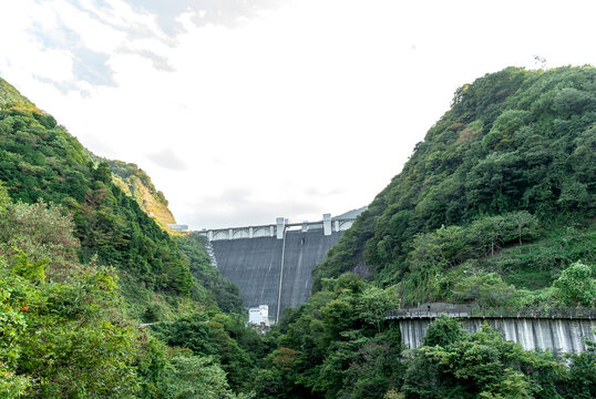 埼玉県秩父市の山間にそびえ立つ浦山ダムの巨大な堤体と周囲を囲む豊かな樹木/Massive Embankment of Urayama Dam Towering in the Mountains of Chichibu with Surrounding Rich Greenery