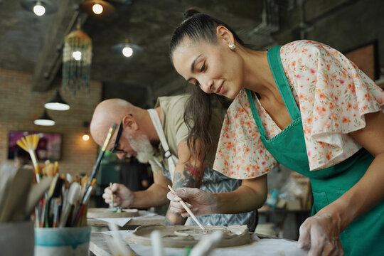 A happy couple makes ceramic plates in a workshop