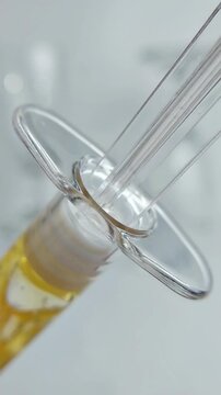 Close up view of a syringe filled with golden yellow liquid. Medical or cosmetic concept, precise application, isolated on clean background for skincare or serum presentation.