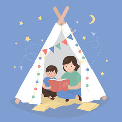 Mother reading for kid. Family sitting in wigwam playhouse with book. Friendly family reading books together at home. Motherhood, mom spending time with son. © Marina
