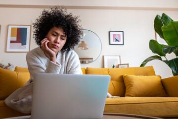 Frustrated woman working remotely from home on laptop