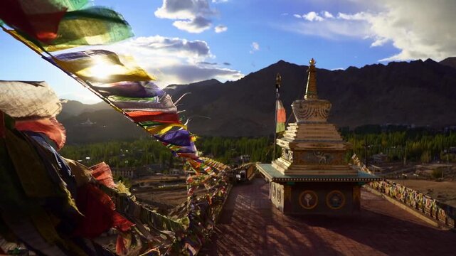 Buddhist Prayer Flags Waving in Wind with Himalayan Mountains and Stupas on Sunny Day
