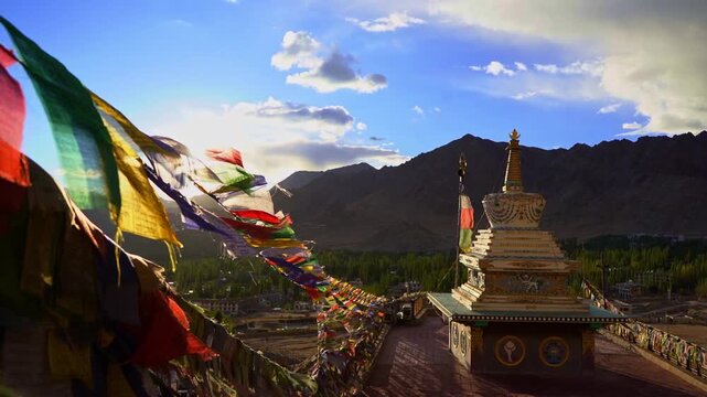 Buddhist Prayer Flags Waving in Wind with Himalayan Mountains and Stupas on Sunny Day