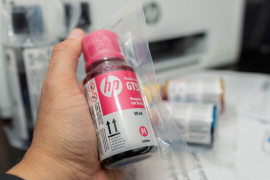 Guayaquil, Ecuador &ndash; July 29, 2025: Hand holding HP GT51 magenta ink bottle for refillable ink tank printer, reflecting growing demand for cost-saving and eco-friendly printing solutions.