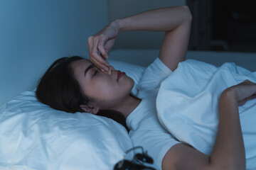 Close-up alarm Young Asian woman have insomnia on the bed