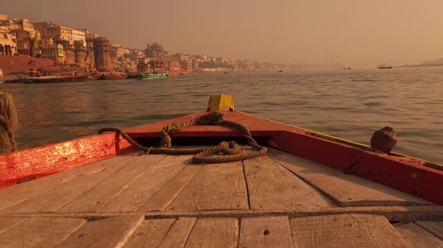 Boat POV Approaching Varanasi Ghats at Sunrise on Ganges River, Golden Morning Light, Spiritual India, Ancient City Architecture, Pilgrimage and Cultural Heritage Scene 4K Footage, India