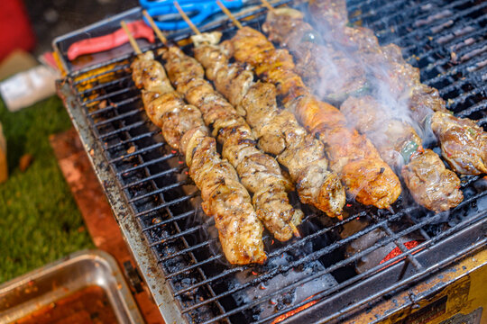 Sate Ayam Skewers Cooking Over Charcoal Fire with Smoke