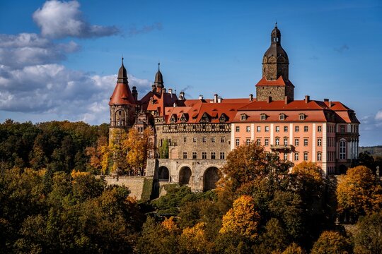 Ksiaz Castle in autumn, colorful fall forest and historic architecture in Lower Silesia, Poland.