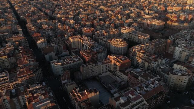 Aerial view of Barcelona city architecture at golden hour with long shadows across residential urban blocks