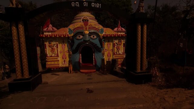 Vibrant and artistic temple entrance in Odisha, India, featuring a decorative face sculpture and colorful traditional design. This unique Hindu shrine architecture reflects rich cultural heritage
