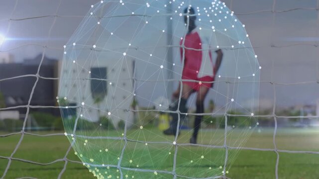 Player running and kicking ball, wireframe sphere tracking ball into net, scoring for sports tech