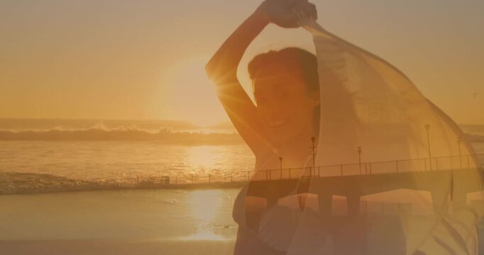 Adult woman lifting sheer scarf, catching light and breeze, pier overlay aligning waist for fashion