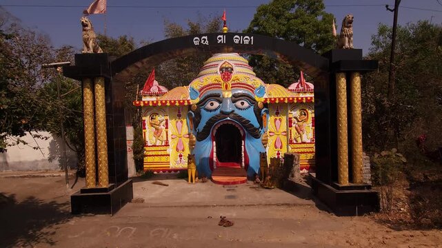 Vibrant and artistic temple entrance in Odisha, India, featuring a decorative face sculpture and colorful traditional design. This unique Hindu shrine architecture reflects rich cultural heritage