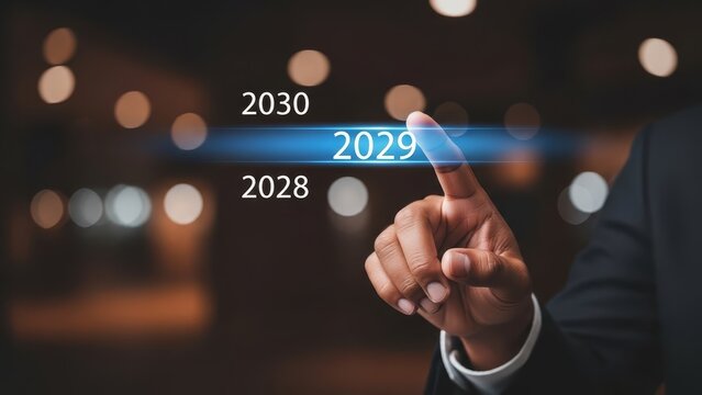Finger selects the year 2029 from a digital interface, representing a choice for future development.