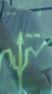 Vertical video: Doctor adjusting stethoscope as pullback revealing green chart rising medical data