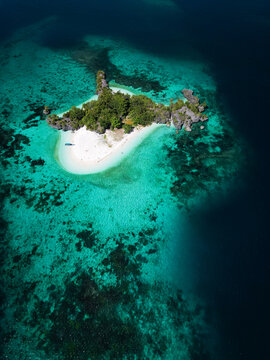 Aerial view of tropical sandbank surrounded by coral reef in Raja Ampat Indonesia