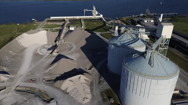 Bulk handling zone near Virginia Ave by Cooper River and North Charleston Terminal centers on radial conveyor distributing material across the yard. Curved machinery, fine-grade aggregate in SC