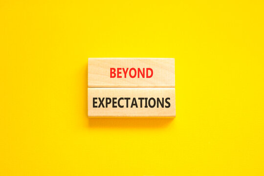 Beyond expectations words symbol. Concept words Beyond expectations on beautiful wooden blocks. Beautiful yellow background. Business and Beyond expectations words concept. Copy space.