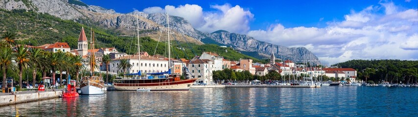 Croatia Makarska Riviera Ultra large 17K Panorama Scenic Waterfront Promenade with Traditional Boats and Old Town Buildings against Biokovo Mountains Backdrop Adriatic Coast Travel Destination