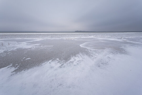 Frozen lake on a cloudy day. Winter landscape.