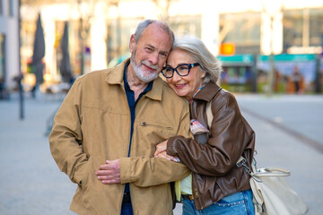 Senior couple sharing love moment on urban street © Miquel