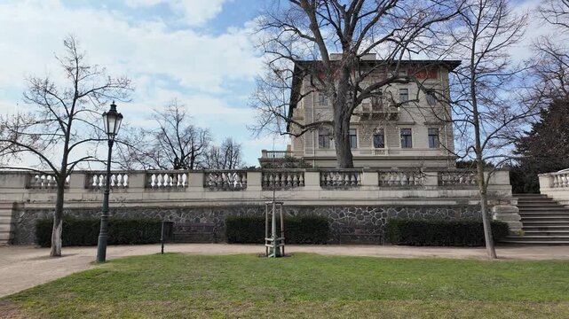 Prague, Czech Republic - March 11, 2026 - Gr&ouml;be Villa in Havlicek Gardens. Elegant building with people and car in winter