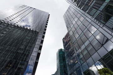 Naklejka premium Looking up at modern office buildings in a downtown financial district