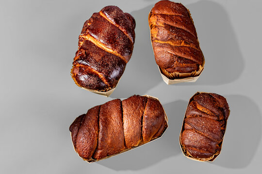 Top view of four freshly baked Romanian cozonacs in paper baking molds.
