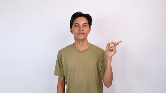 Asian young man smiling gesturing pointing to the side