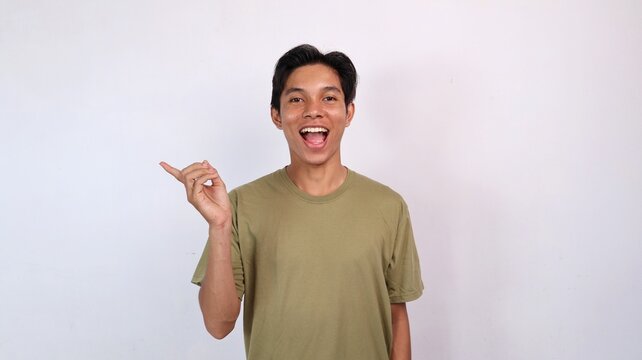 excited young asian man gestures pointing to the side