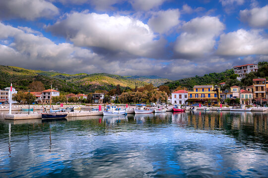 Platania village harbor in South Pelion showing fishing boats docked along the waterfront and traditional buildings.