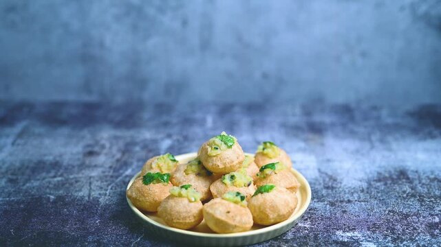 Close up of Indian street food fuchka on a plate glass with sour spicy water. Dahi Pani puri a chat item in India. 4K indian street food snacks.