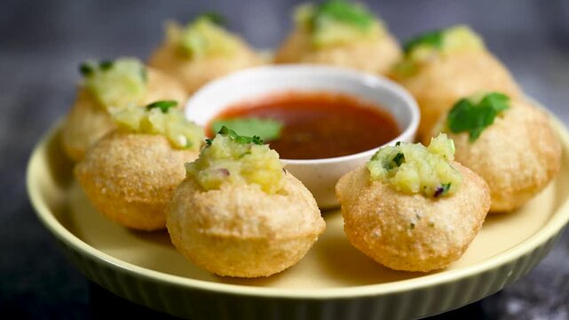 Close up of Indian street food fuchka on a plate glass with sour spicy water. Dahi Pani puri a chat item in India. 4K indian street food snacks.