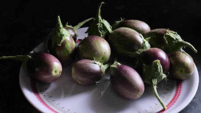 Group of fresh raw organic eggplants on a plate