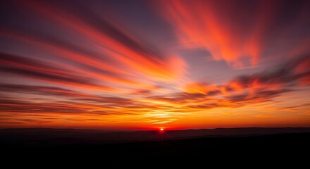 Fototapeta premium Fiery Sunset Burst - Vibrant Orange and Purple Sky with Dynamic Cloud Streaks.