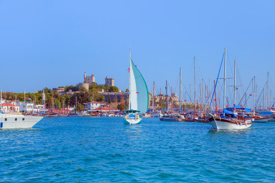 Lone white sail yact near Saint Peter Castle or Bodrum castle and marina in Bodrum, Turkey