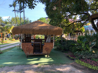 Fototapeta premium bamboo hut with a grass roof located in a park.